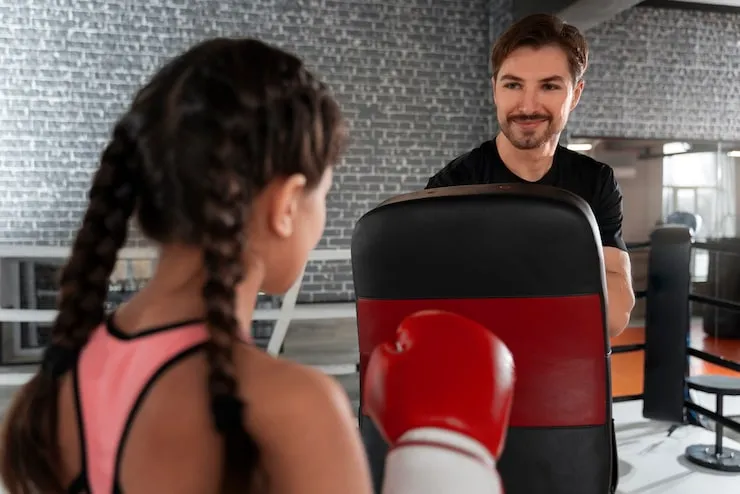 medium-shot-coach-helping-girl_2 boxing with gtc